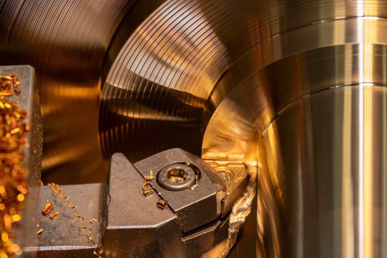Drehbearbeitung eines Bauteils auf der Werkzeugmaschine, glänzende Metalloberfläche mit Spänen.
